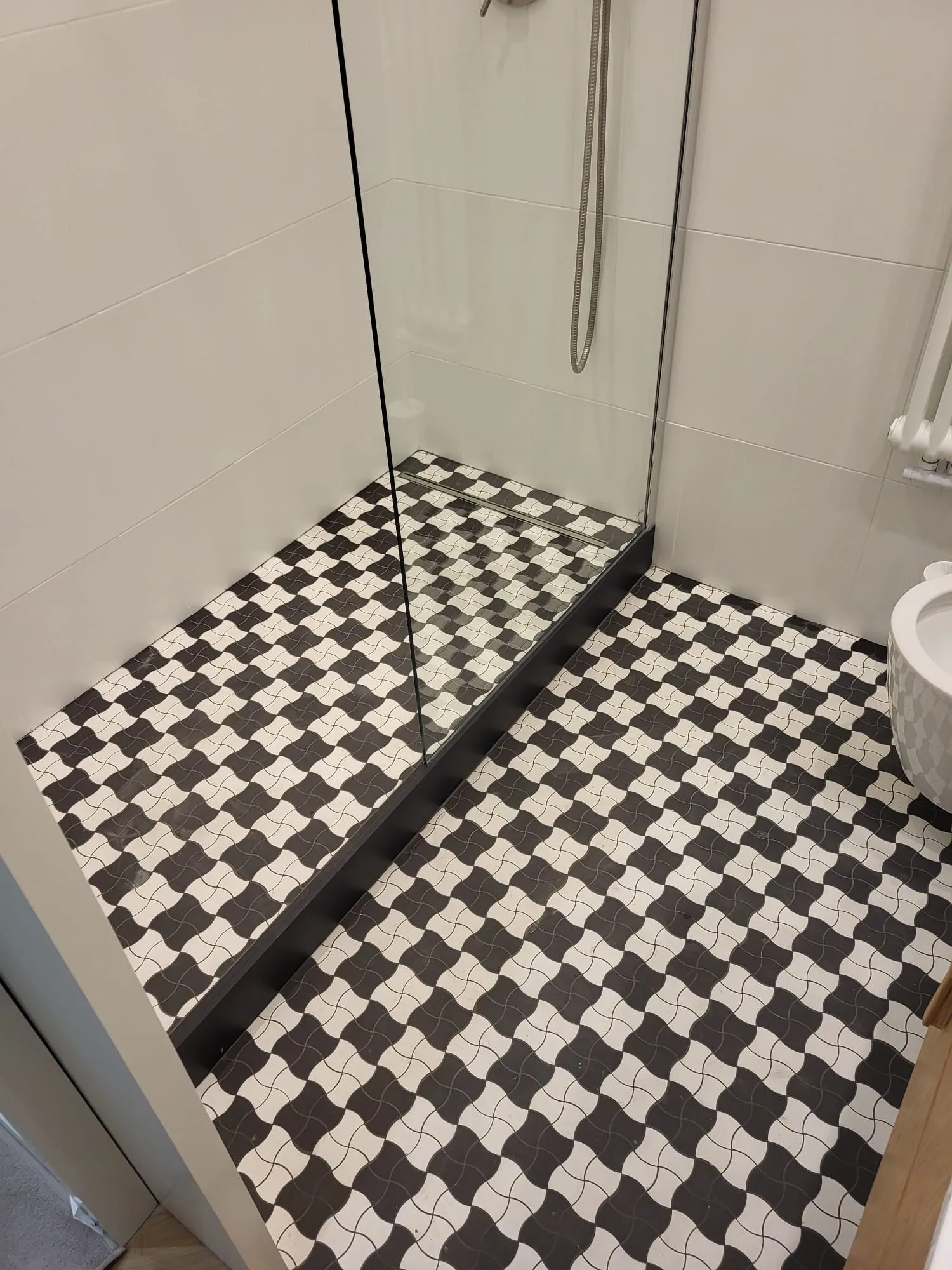 Łazienka z prysznicem i kafelkami w szachownicę