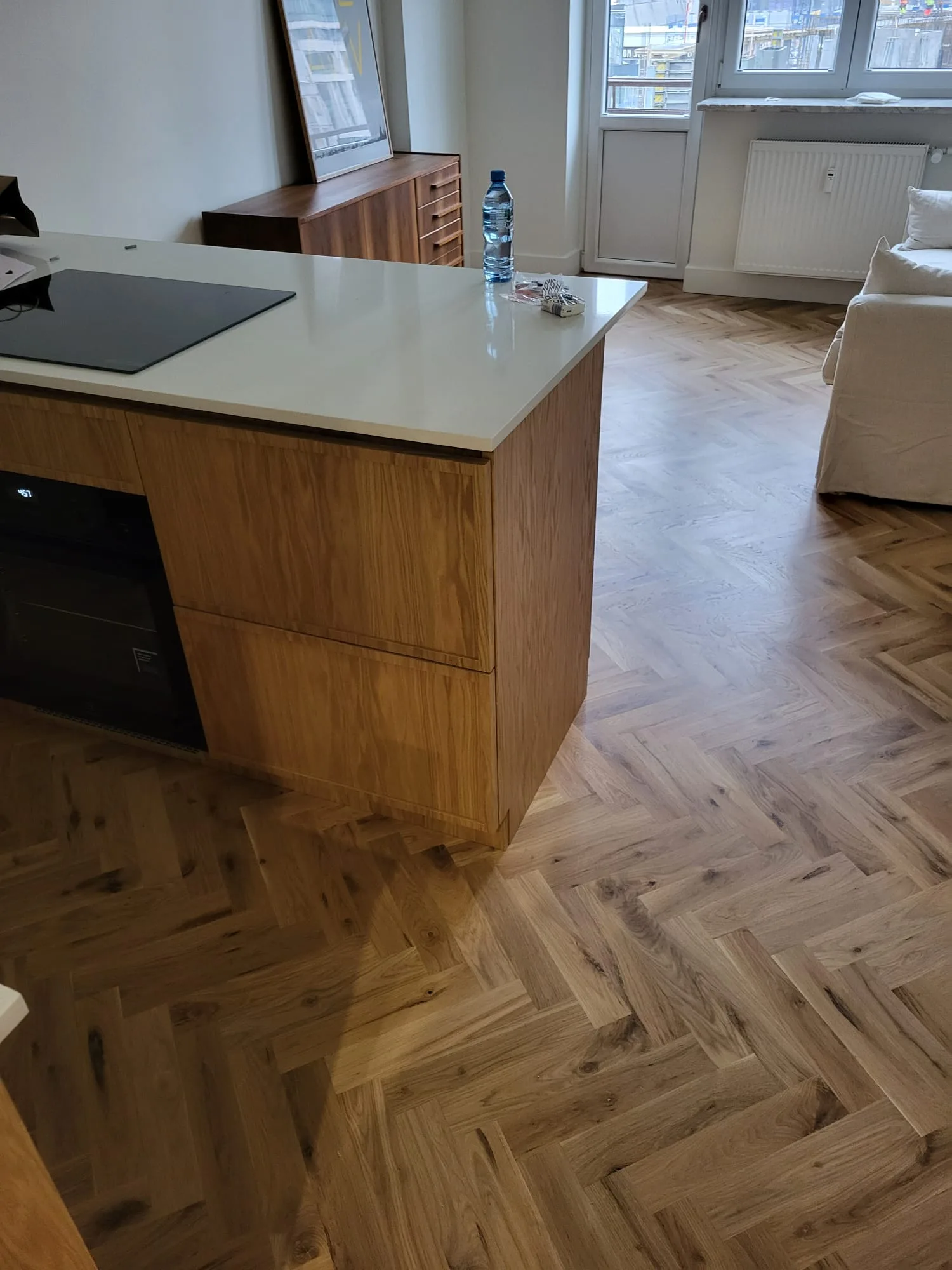 Nowoczesna kuchnia z wyspą i drewnianym parkietem