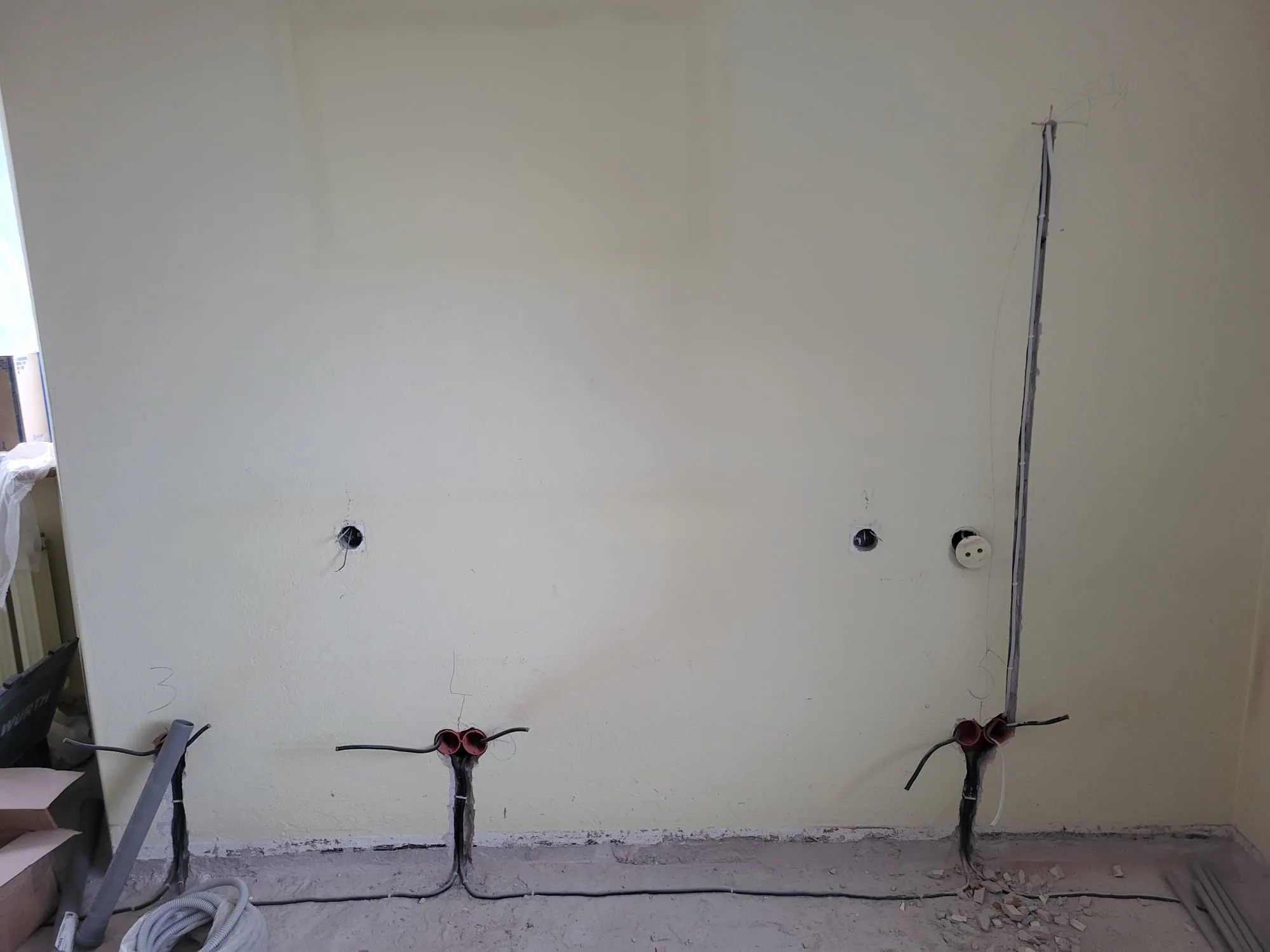 Przygotowanie do instalacji elektrycznych w remontowanej przestrzeni. Widoczne połączenia i gniazda