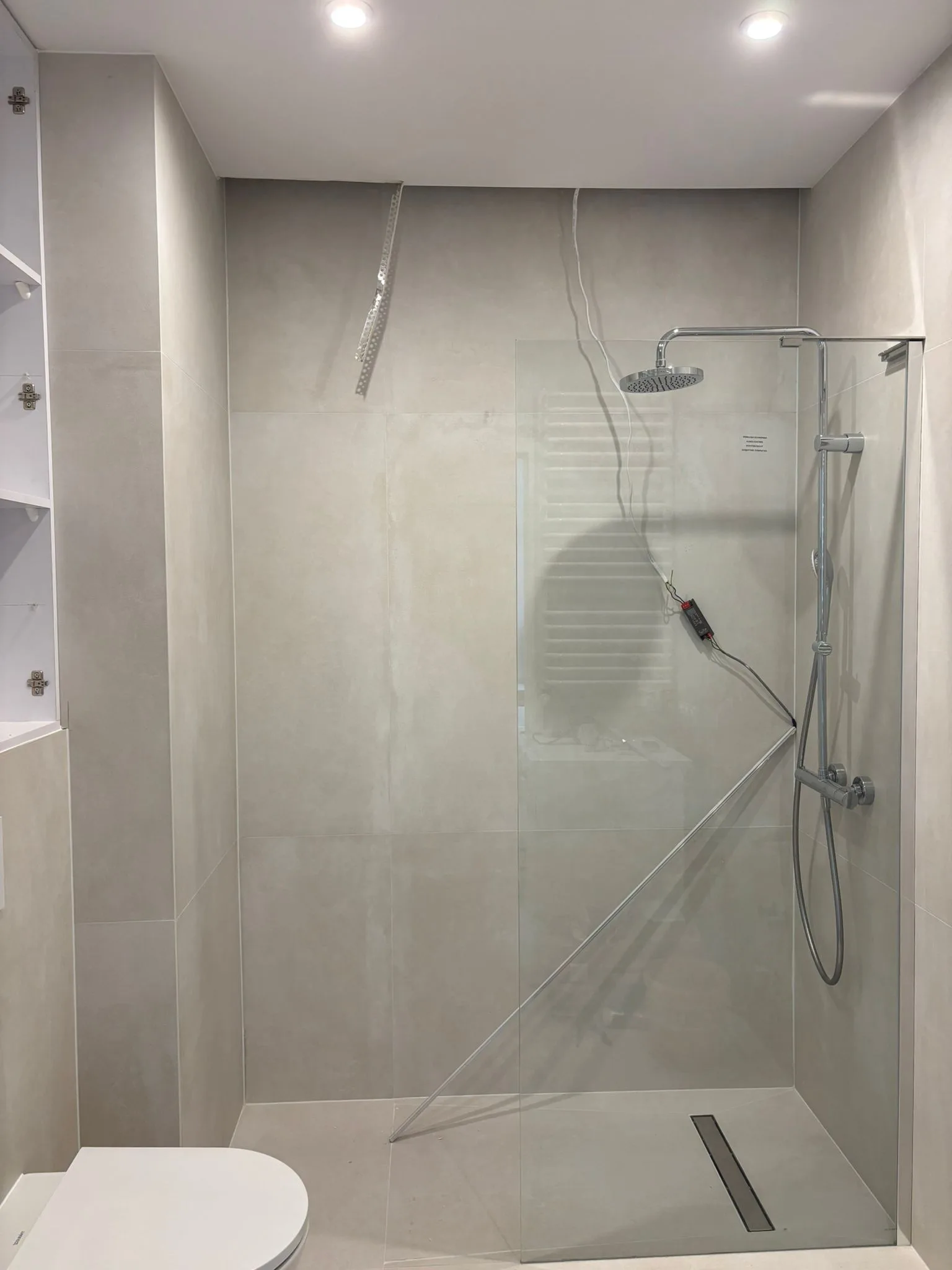 Nowoczesna łazienka z przeszkloną kabiną prysznicową oraz płytkami ceramicznymi