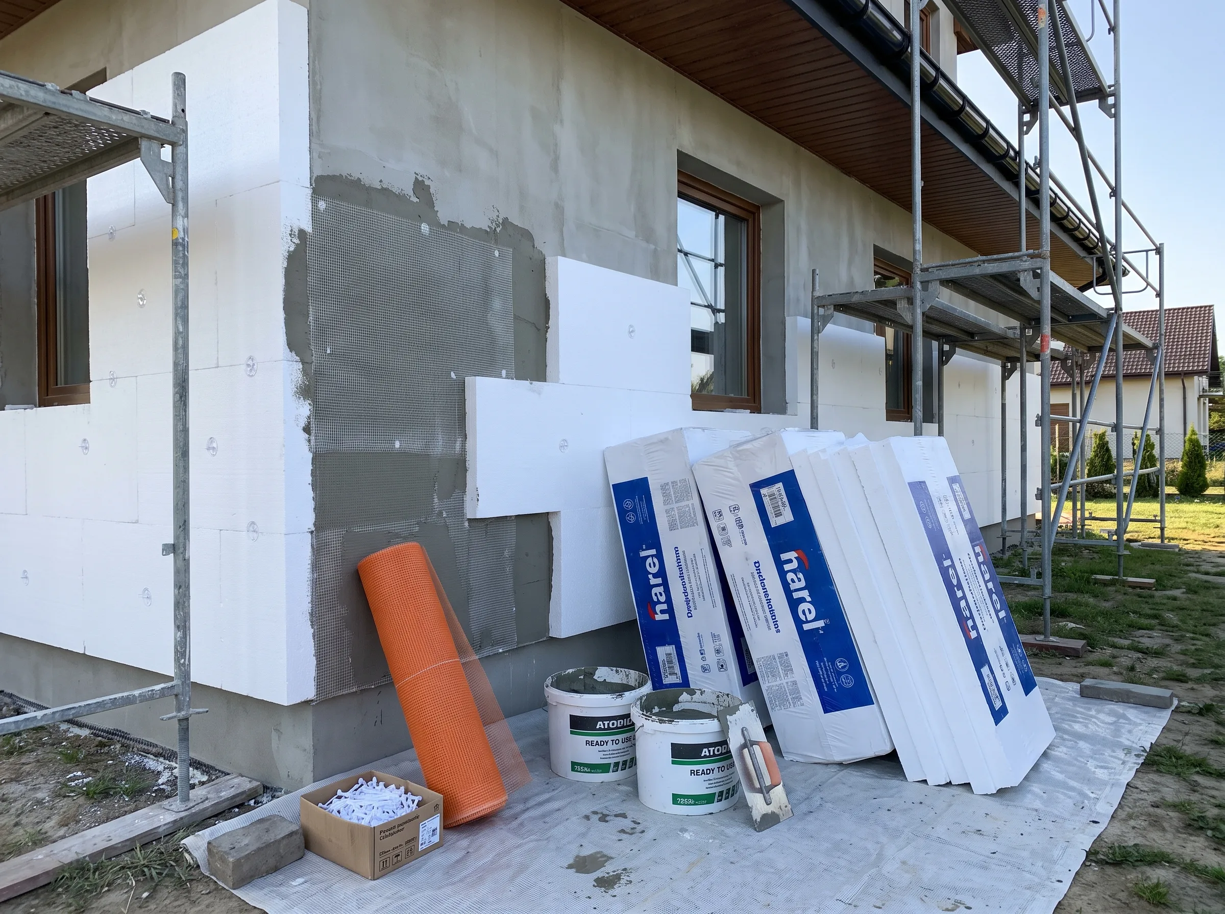 Materiały do ocieplenia budynku: płyty styropianowe, klej oraz siatka na elewację